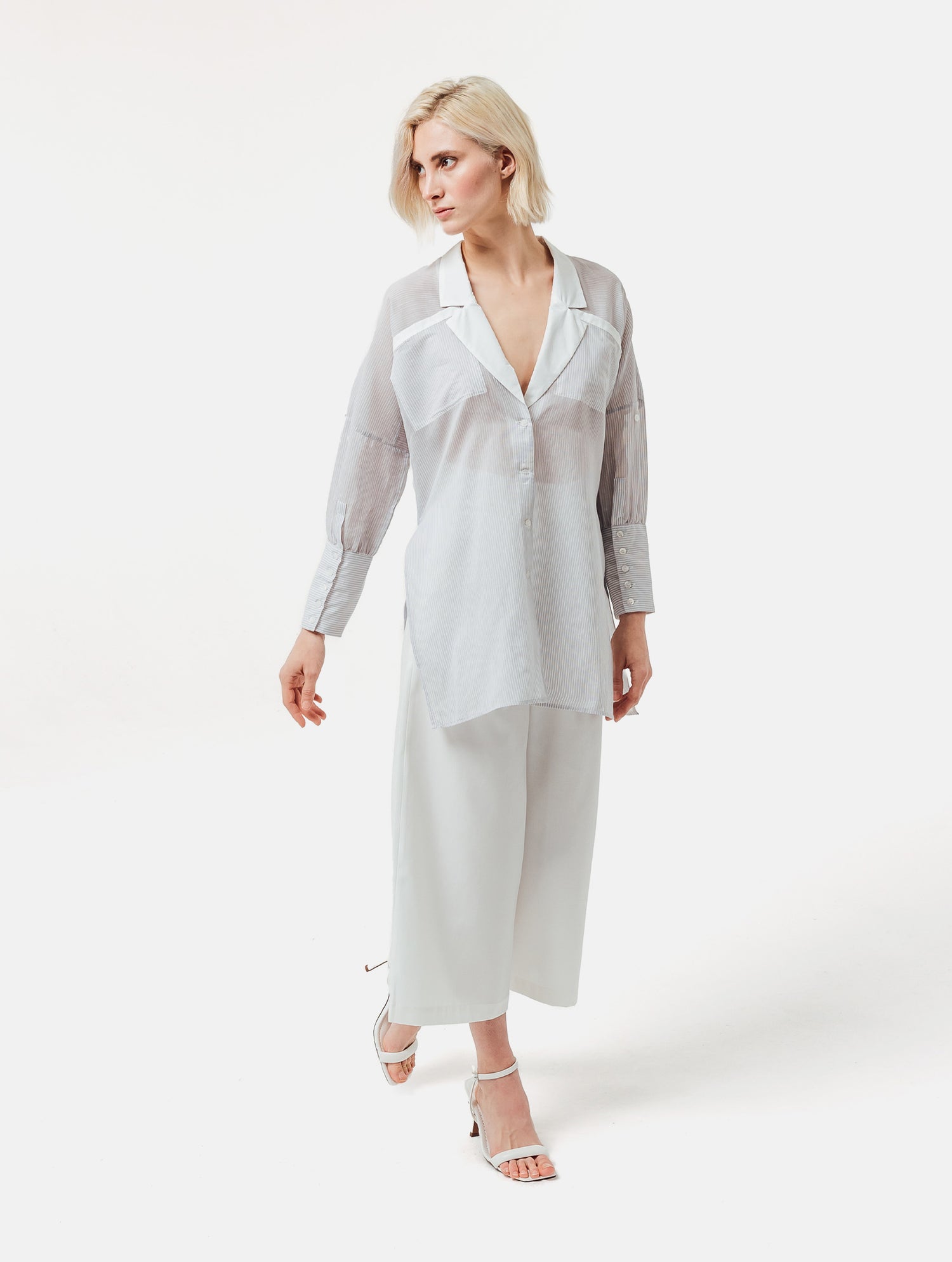 Gestreifte Oversized-Bluse mit hohen Seitenschlitzen, breiten Manschetten und geschwungener Rückenpasse.