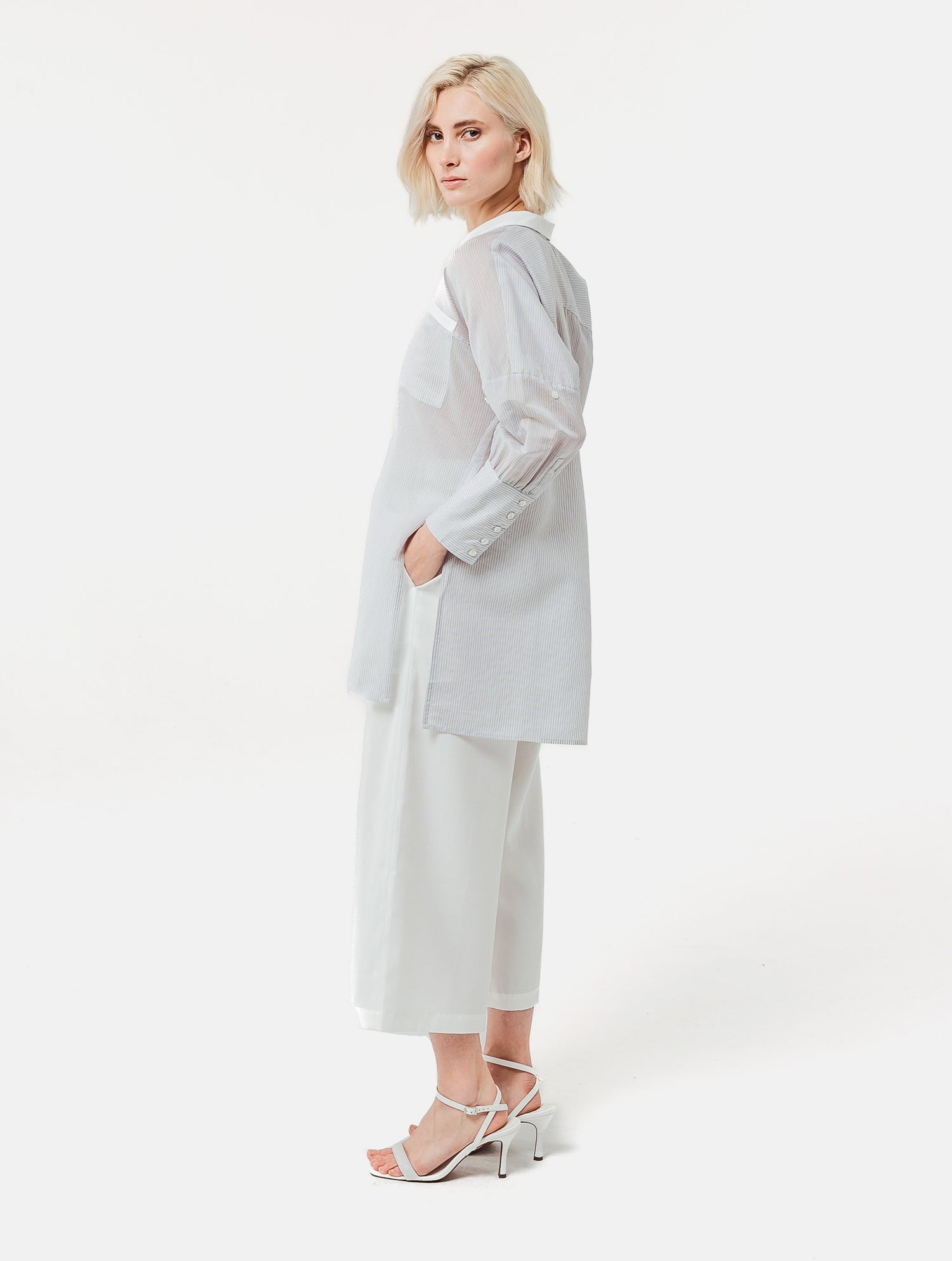 Gestreifte Oversized-Bluse mit hohen Seitenschlitzen, breiten Manschetten und geschwungener Rückenpasse.