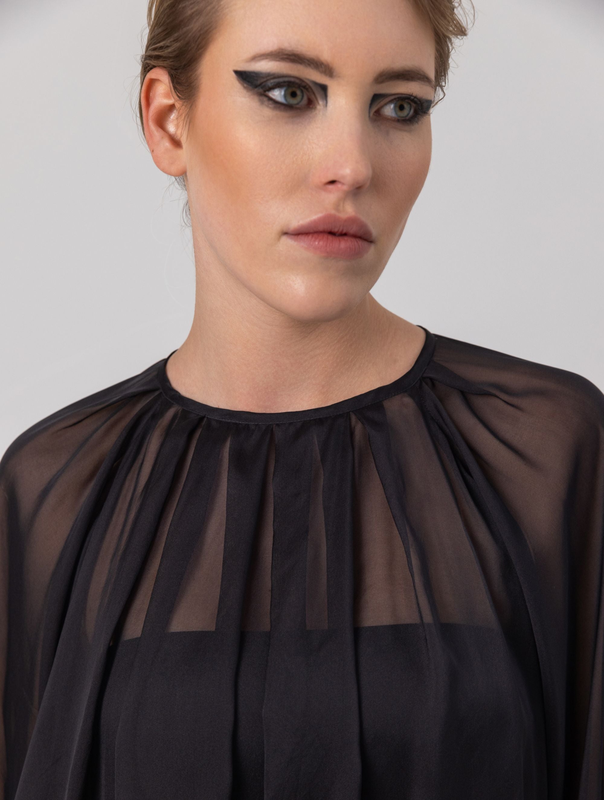 Weite Bluse mit Rundhalsausschnitt, Falten auf der Vorder- und Rückseite und Raglan-Dichterärmeln.    Dieses Modell ist Teil unserer REBORN-Kollektion und steht für unsere "Zero-Waste-Politik".  