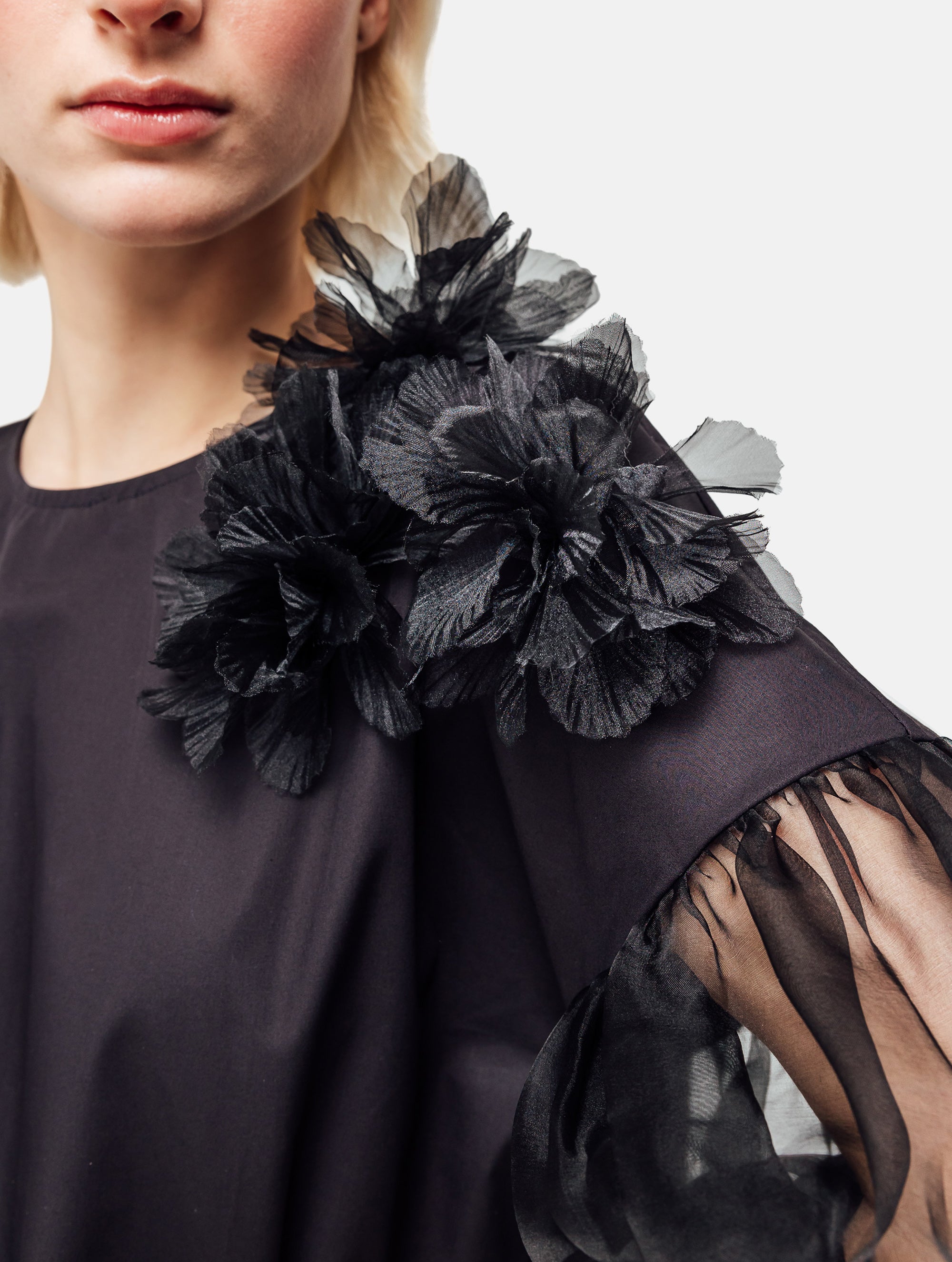 Bluse mit Rundhalsausschnitt, Organza-Ärmeln, sowie Bluemnapplikationen und kleinen
Seitenschlitzen. Versteckten Seitentaschen in der Seitennaht. Dieses Produkt ist Teil unserer Reborn Linie.