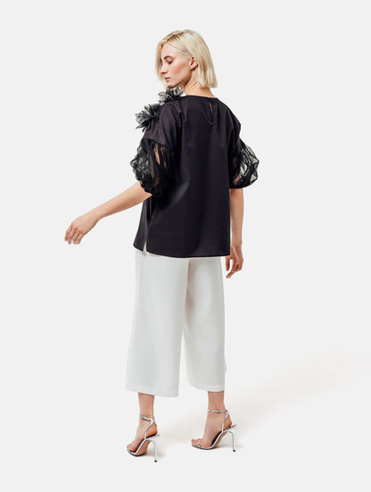 Bluse mit Rundhalsausschnitt, Organza-Ärmeln, sowie Bluemnapplikationen und kleinen
Seitenschlitzen. Versteckten Seitentaschen in der Seitennaht. Dieses Produkt ist Teil unserer Reborn Linie.