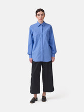 Langes Oversize Blusenhemd mit klassischem Hemdkragen und Manschetten, sowie zwei aufgesetzten Brutstaschen und abgerundeten Saumende im Rückteil.  Dieses Modell ist Teil unserer REBORN-Linie und steht für unsere "Zero-Waste-Politik", da mit Stoff aus Altbestand gefertigt.