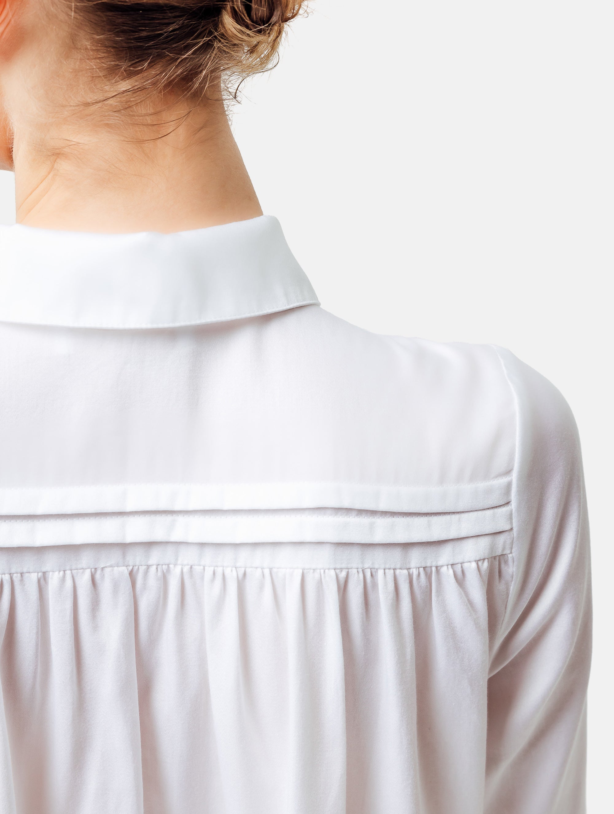 Weites Hemdkragenkleid mit Biesen an der Schulter, verdeckter Knopfleiste und Volant am Saumende. Made of premium cotton with a satin touch.