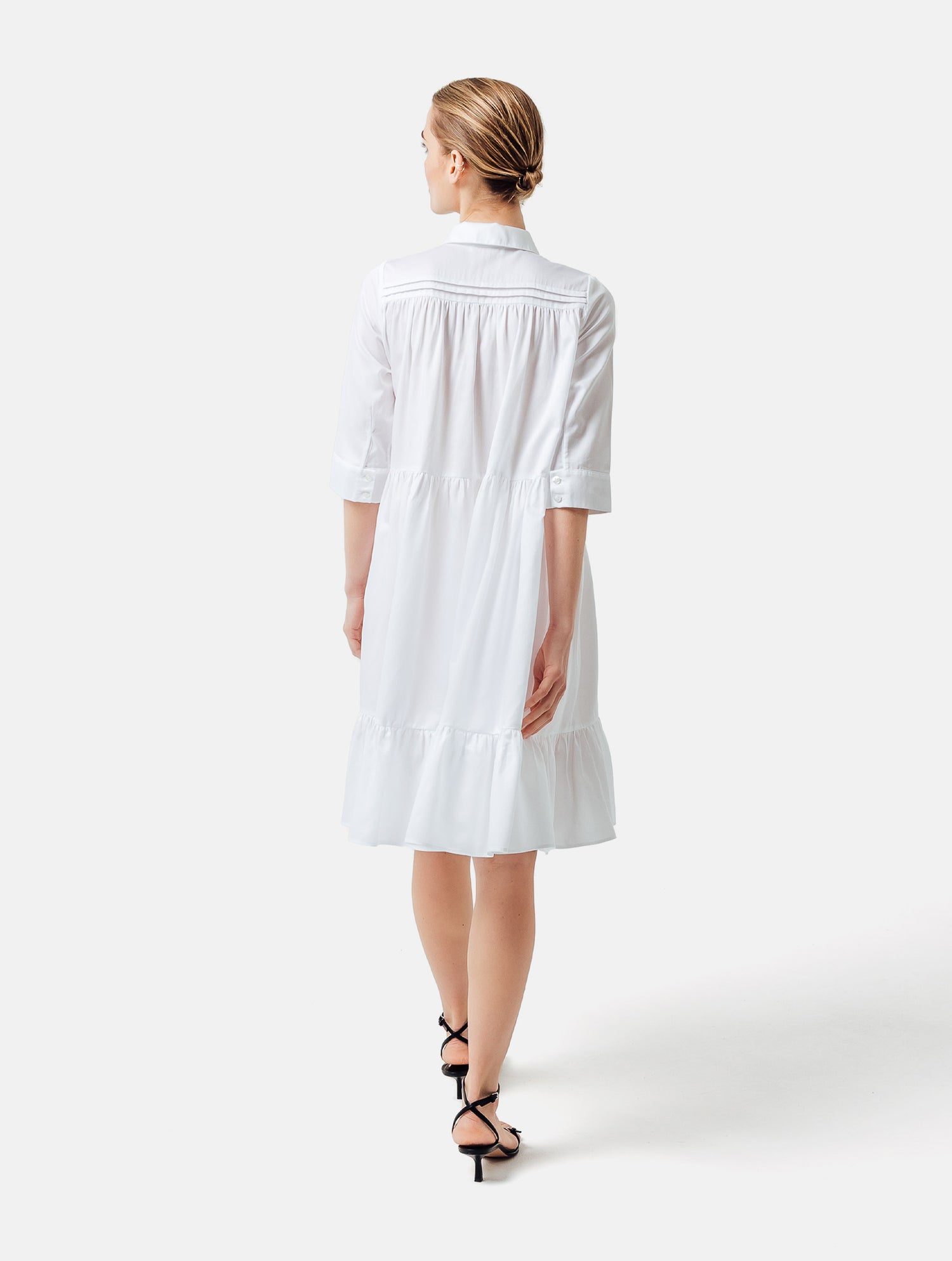 Weites Hemdkragenkleid mit Biesen an der Schulter, verdeckter Knopfleiste und Volant am Saumende. Made of premium cotton with a satin touch.