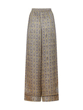 Bedruckte Satin-Seidenhose mit weitem Bein im Pyjama-Stil, elastischem Bund, Seitentaschen und schwarzen Paspeln. Hergestellt aus Naturfaser.