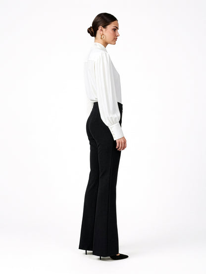 Die Hose Tanja in klassischem Schwarz überzeugt mit klarer Linienführung, eleganter Wide-Leg-Silhouette und hohem Bund mit elastischem Taillenband für eine bequeme, schmeichelhafte Passform.