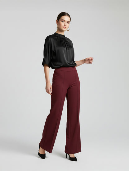 Die Hose Tanja in klassischem Weinrot überzeugt mit klarer Linienführung, eleganter Wide-Leg-Silhouette und hohem Bund mit elastischem Taillenband für eine bequeme, schmeichelhafte Passform.