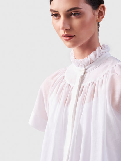 Transparente Bluse mit Stehkragen, auffälligen Ärmeln und durchgehender Knopfleiste auf der Vorderseite. Gefertigt aus einer hochwertigen Baumwoll-Seiden-Mischung.