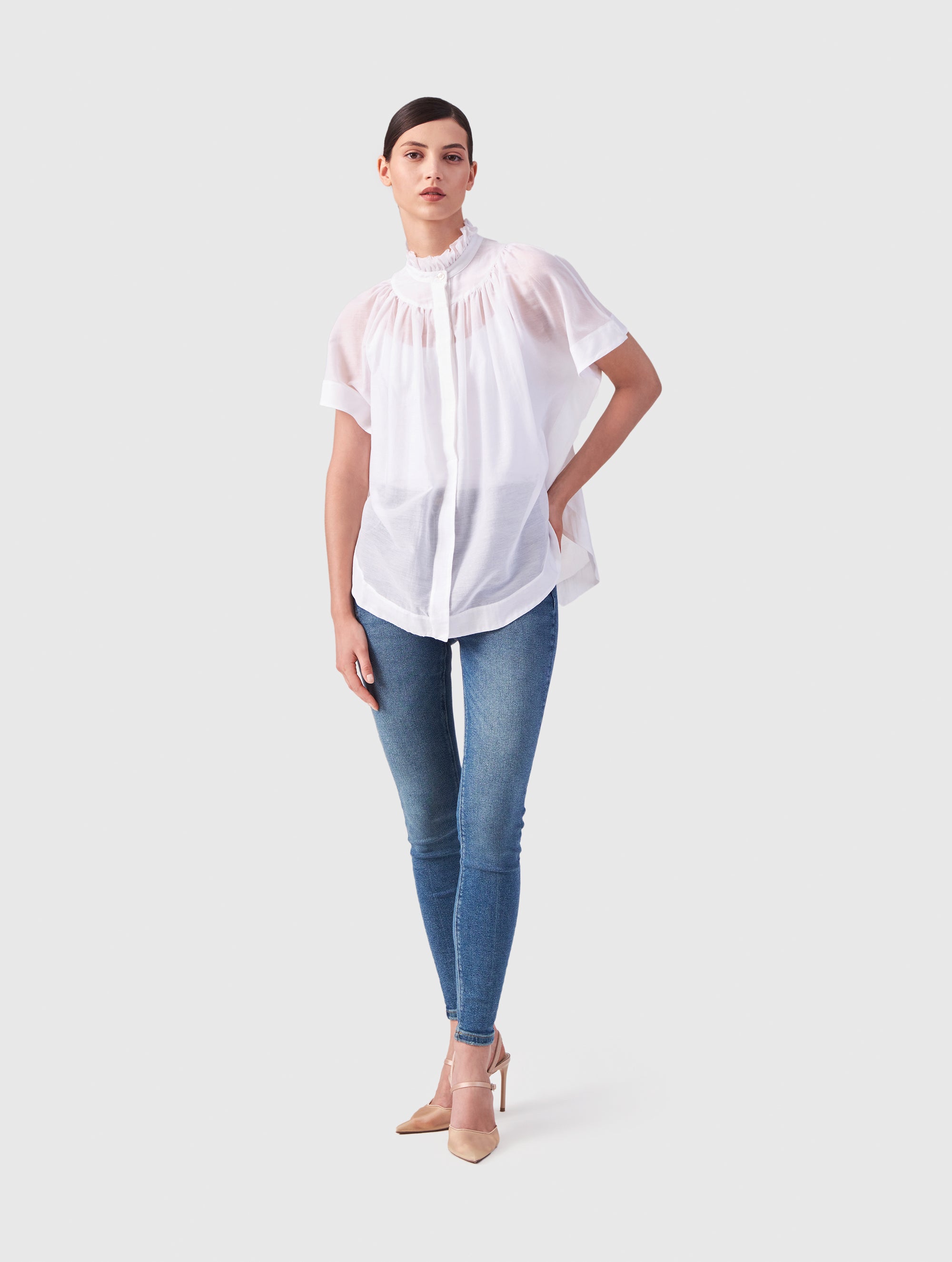 Transparente Bluse mit Stehkragen, auffälligen Ärmeln und durchgehender Knopfleiste auf der Vorderseite. Gefertigt aus einer hochwertigen Baumwoll-Seiden-Mischung.