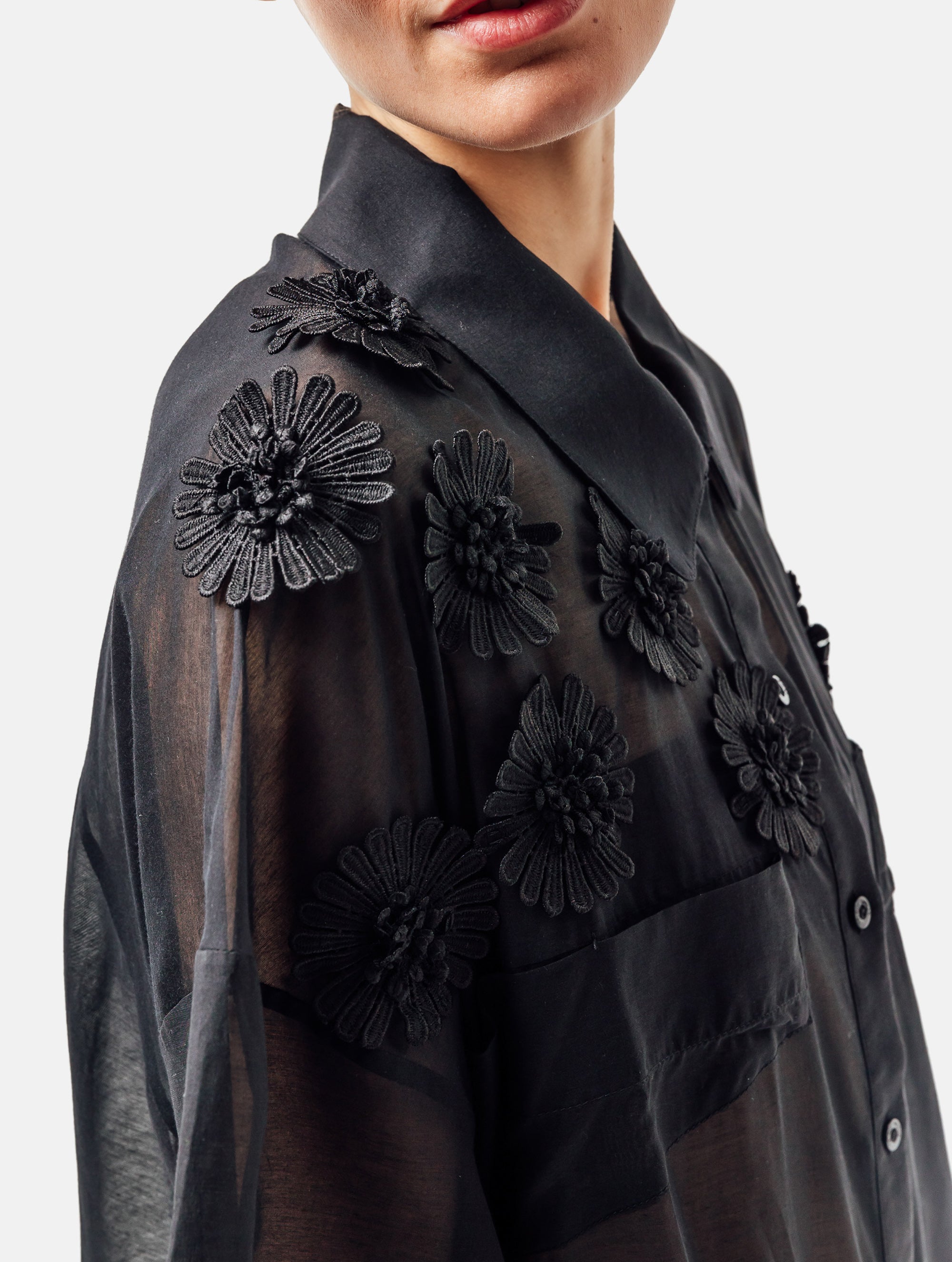 Ultraleichtes Kaftankleid mit Blumenapplikationen, Hemdkragen und langer Knopfleiste vorne, hohen Seitenschlitzen, sowie großen Brusttaschen. Dieses Produkt ist Teil unserer Reborn Linie.
