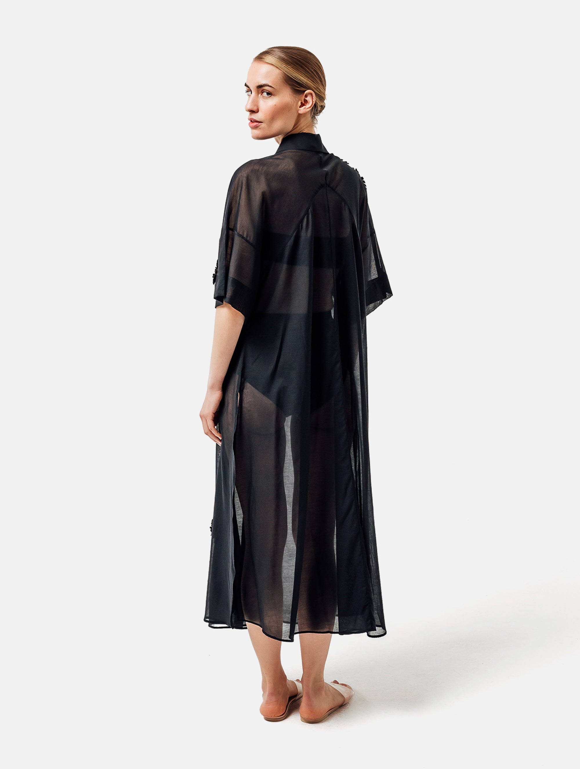 Ultraleichtes Kaftankleid mit Blumenapplikationen, Hemdkragen und langer Knopfleiste vorne, hohen Seitenschlitzen, sowie großen Brusttaschen. Dieses Produkt ist Teil unserer Reborn Linie.