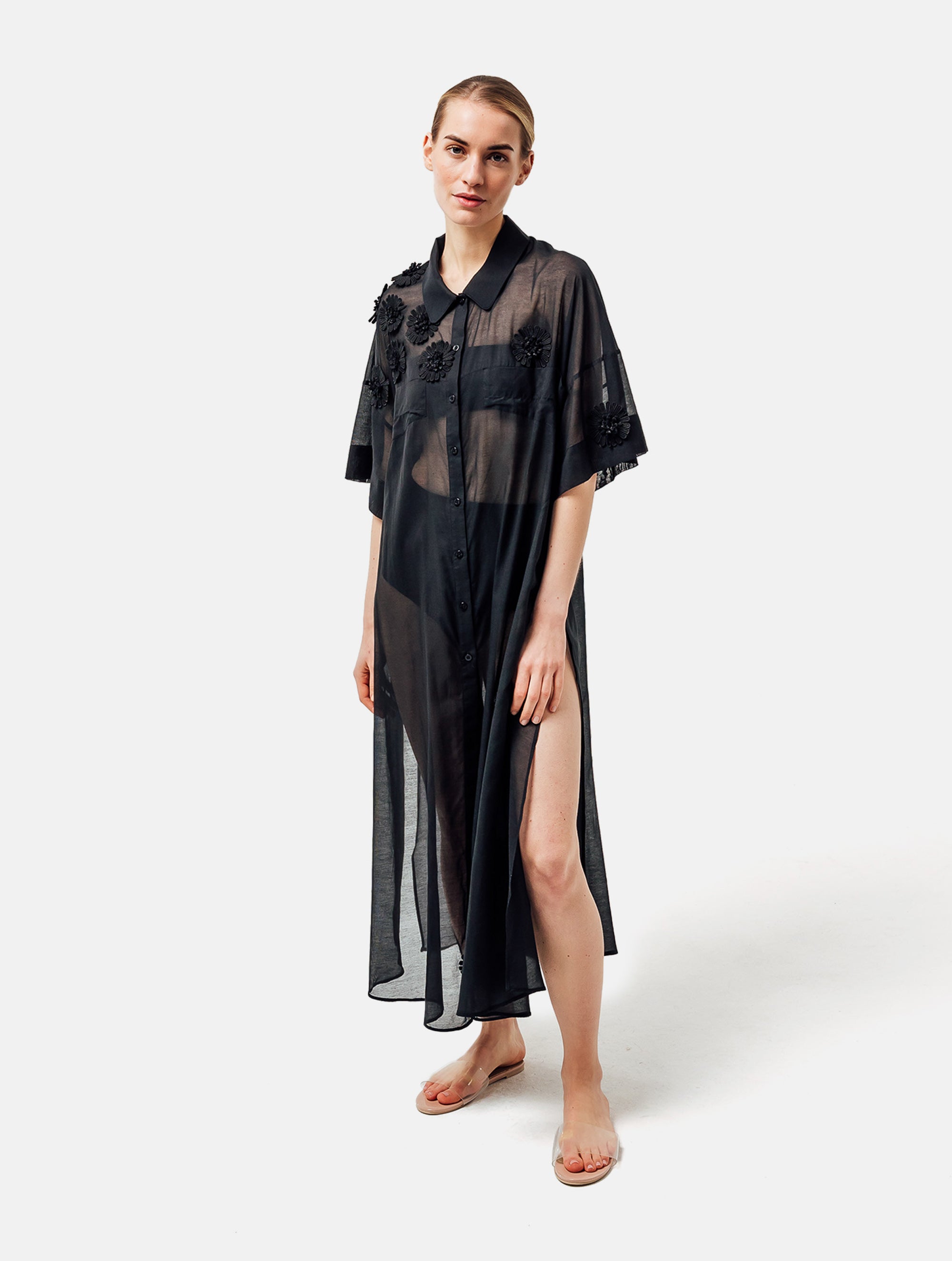 Ultraleichtes Kaftankleid mit Blumenapplikationen, Hemdkragen und langer Knopfleiste vorne, hohen Seitenschlitzen, sowie großen Brusttaschen. Dieses Produkt ist Teil unserer Reborn Linie.