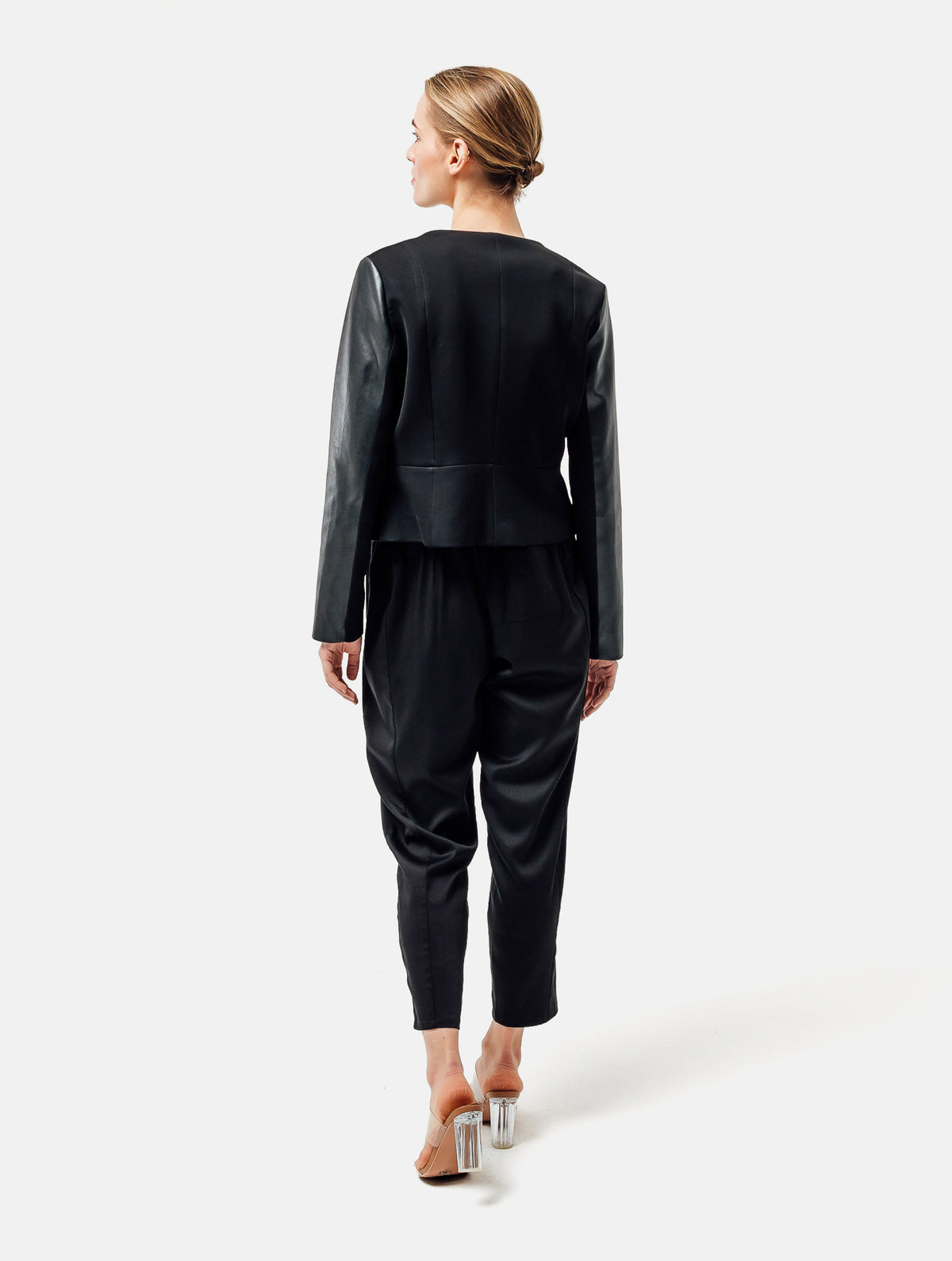 Einknöpfiger, taillierter Zwei-Komponenten Kurzblazer aus veganem Leder im Vorderteil und Scuba-Jersey im Rückteil, sowie schmalen Arm. Dieses Modell ist Teil unserer REBORN-Linie und steht für unsere "Zero-Waste-Politik", da mit Stoff aus Altbestand gefertigt.