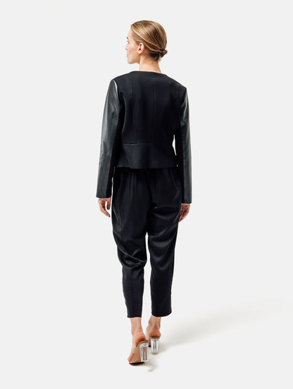 Einknöpfiger, taillierter Zwei-Komponenten Kurzblazer aus veganem Leder im Vorderteil und Scuba-Jersey im Rückteil, sowie schmalen Arm. Dieses Modell ist Teil unserer REBORN-Linie und steht für unsere "Zero-Waste-Politik", da mit Stoff aus Altbestand gefertigt.
