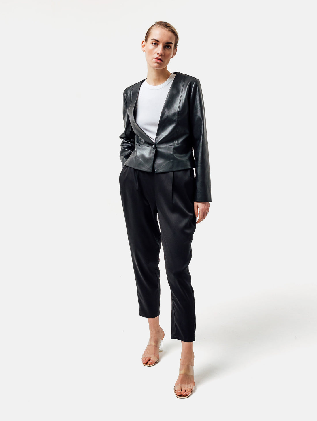 Einknöpfiger, taillierter Zwei-Komponenten Kurzblazer aus veganem Leder im Vorderteil und Scuba-Jersey im Rückteil, sowie schmalen Arm. Dieses Modell ist Teil unserer REBORN-Linie und steht für unsere "Zero-Waste-Politik", da mit Stoff aus Altbestand gefertigt.