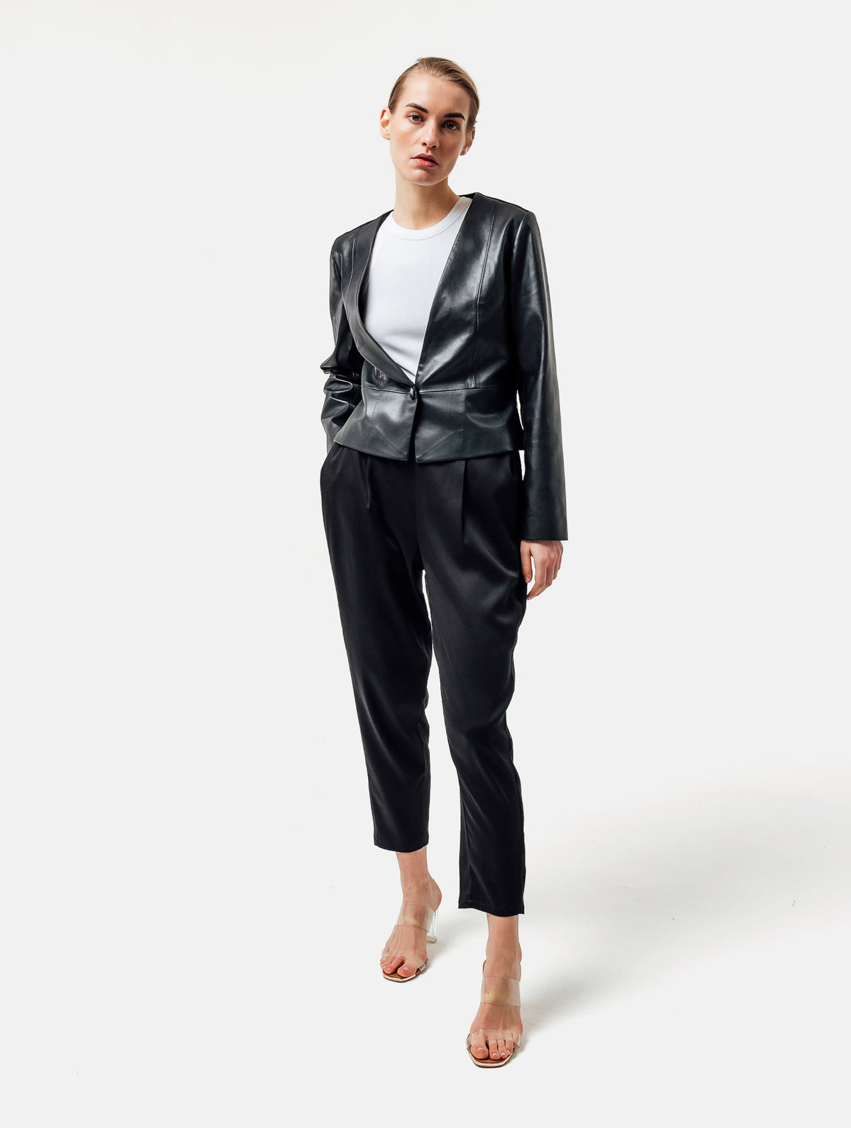 Einknöpfiger, taillierter Zwei-Komponenten Kurzblazer aus veganem Leder im Vorderteil und Scuba-Jersey im Rückteil, sowie schmalen Arm. Dieses Modell ist Teil unserer REBORN-Linie und steht für unsere "Zero-Waste-Politik", da mit Stoff aus Altbestand gefertigt.