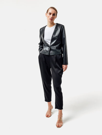 Einknöpfiger, taillierter Zwei-Komponenten Kurzblazer aus veganem Leder im Vorderteil und Scuba-Jersey im Rückteil, sowie schmalen Arm. Dieses Modell ist Teil unserer REBORN-Linie und steht für unsere "Zero-Waste-Politik", da mit Stoff aus Altbestand gefertigt.