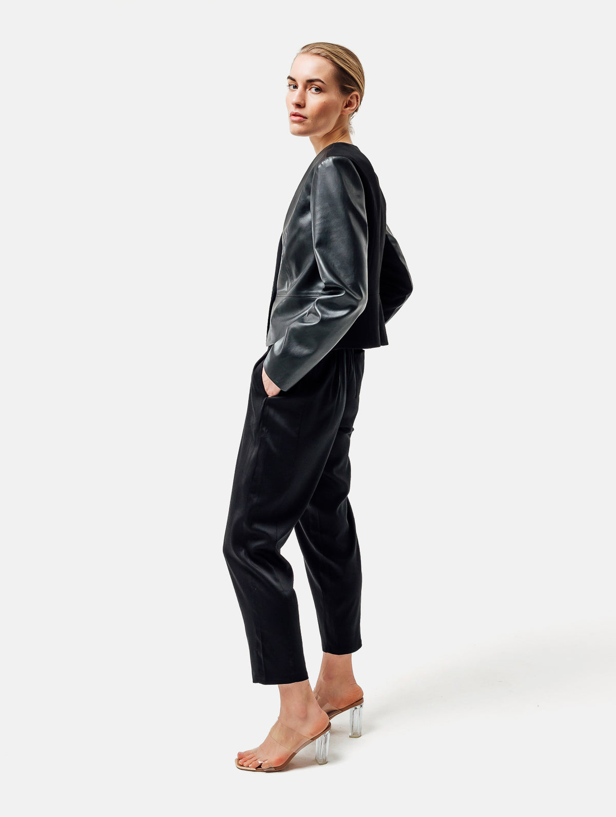 Einknöpfiger, taillierter Zwei-Komponenten Kurzblazer aus veganem Leder im Vorderteil und Scuba-Jersey im Rückteil, sowie schmalen Arm. Dieses Modell ist Teil unserer REBORN-Linie und steht für unsere "Zero-Waste-Politik", da mit Stoff aus Altbestand gefertigt.