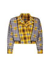 Doppelseitige Karo-Kurzjacke mit abnehmbaren Schulterpolstern, eingesetzten Ärmeln mit Ärmelgürteln und Schulterklappen sowie vorderen Halbpasse. Die Jacke kann von beiden Seiten getragen werden.   Hergestellt aus Naturfasern. 