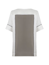 Zweifarbiges, locker geschnittenes Shirt mit weitem Halsauschnitt und schwarzem Piping Detail. Stoffe kommen aus dem Altbestand der Firma, daher nachhaltig.
