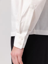 Locker geschnittene Bluse mit Stehkragen und schräger Knopfleiste auf der Vorderseite. Hergestellt aus Naturfasern.