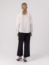 Locker geschnittene Bluse mit Stehkragen und schräger Knopfleiste auf der Vorderseite. Hergestellt aus Naturfasern.