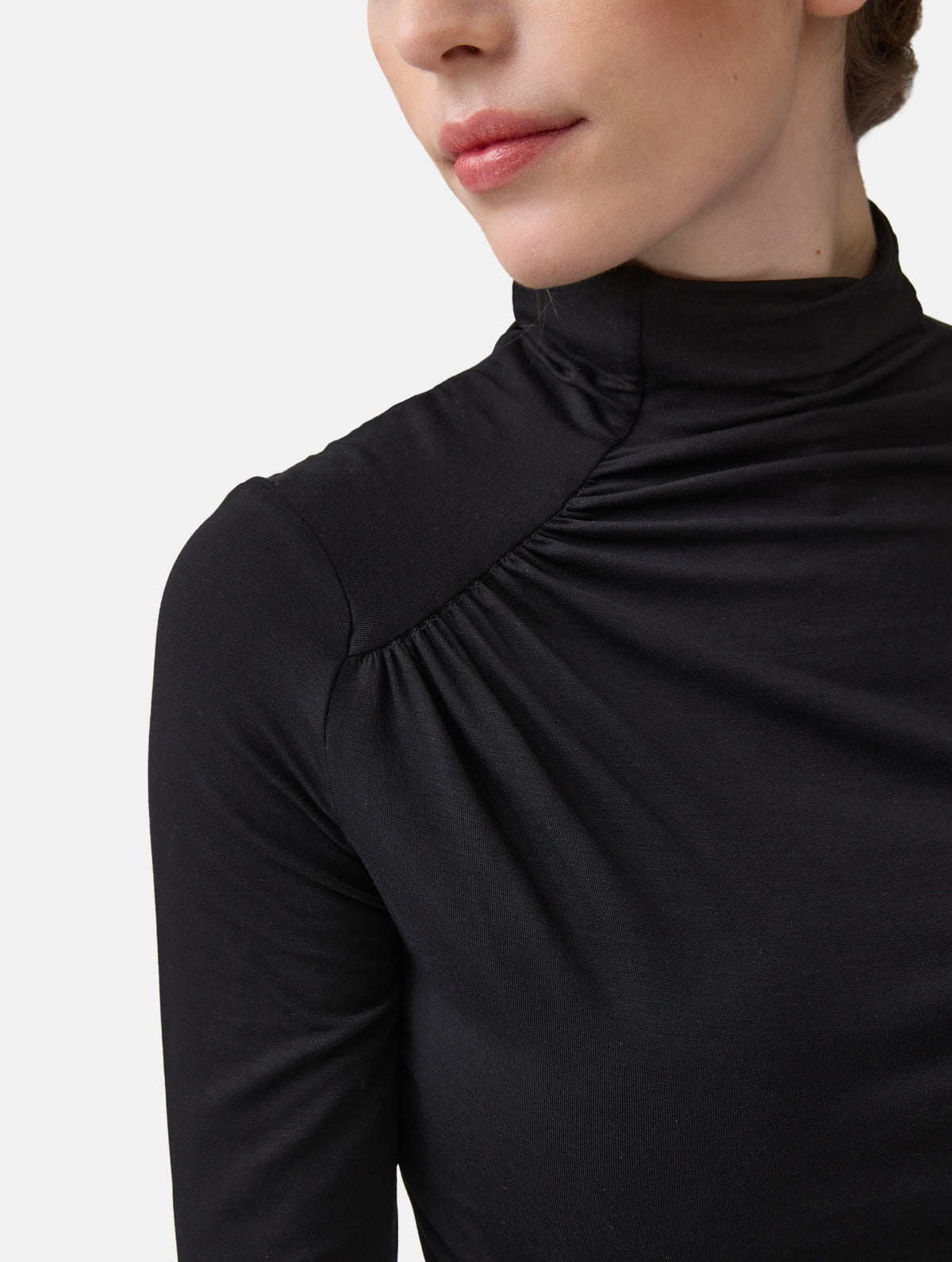 Figurbetontes Longsleeve mit Hochkragen aus ultraweichen Light-Jersey und Raffung am Hals, sowie der gegenüberliegenden Seite auf Höhe der Taille.