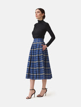 Weit ausgestellter Midirock aus karierter Baumwolle mit in Falten gelegtem und tailliertem Rockbund, versteckten Taschen in der Seitennaht, sowie einem Reißverschluß auf der Rückseite. Dieses Modell ist Teil unserer REBORN-Linie und steht für unsere "Zero-Waste-Politik", da mit Stoff aus einem Deadstock stammt.