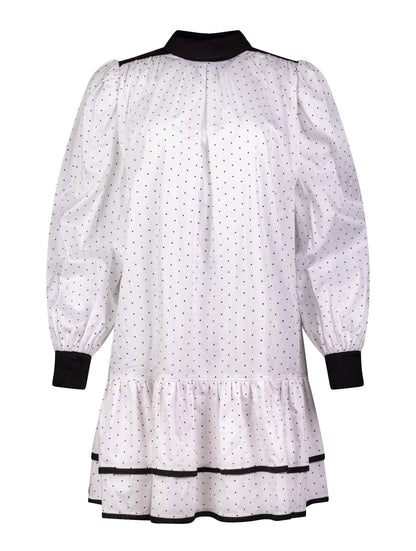 Grade geschnittenes Minikleid aus gepunkteter Baumwolle mit farblich abgesetzten Kragen und Manschetten aus schwarzer Chiffonseide, sowie doppelten Volantssaum. 