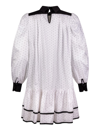 Grade geschnittenes Minikleid aus gepunkteter Baumwolle mit farblich abgesetzten Kragen und Manschetten aus schwarzer Chiffonseide, sowie doppelten Volantssaum. 