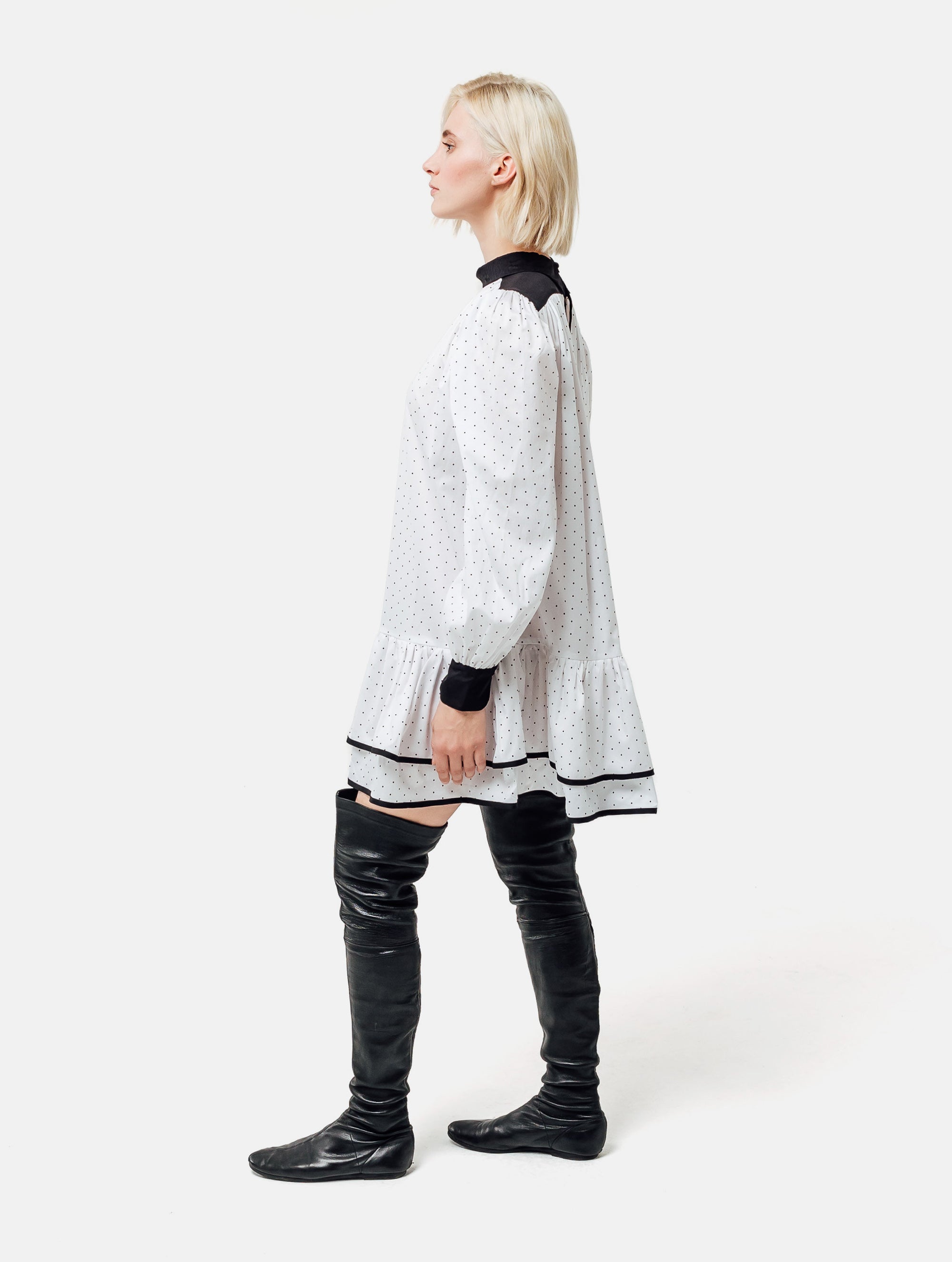 Grade geschnittenes Minikleid aus gepunkteter Baumwolle mit farblich abgesetzten Kragen und Manschetten aus schwarzer Chiffonseide, sowie doppelten Volantssaum. 