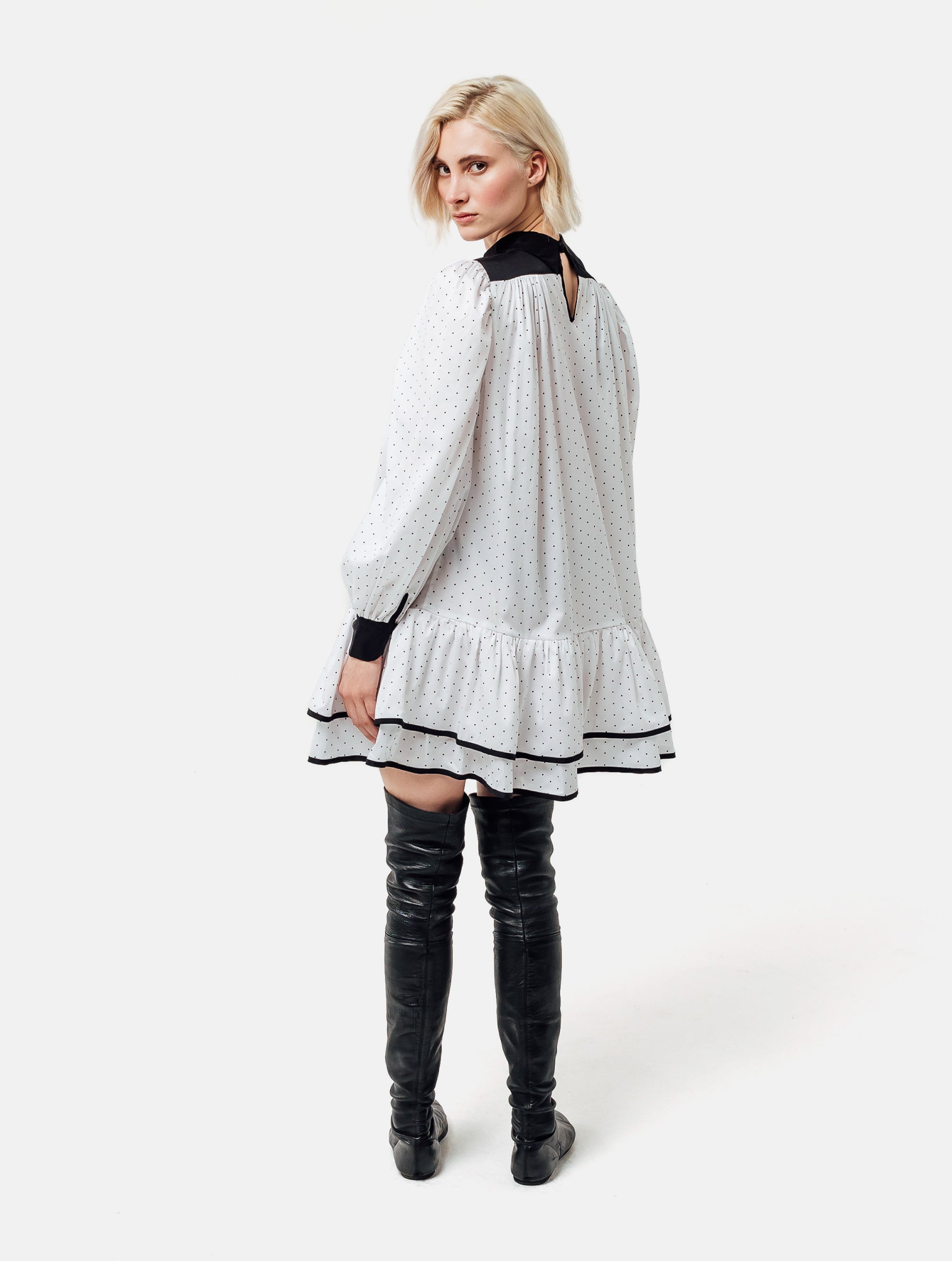 Grade geschnittenes Minikleid aus gepunkteter Baumwolle mit farblich abgesetzten Kragen und Manschetten aus schwarzer Chiffonseide, sowie doppelten Volantssaum. 