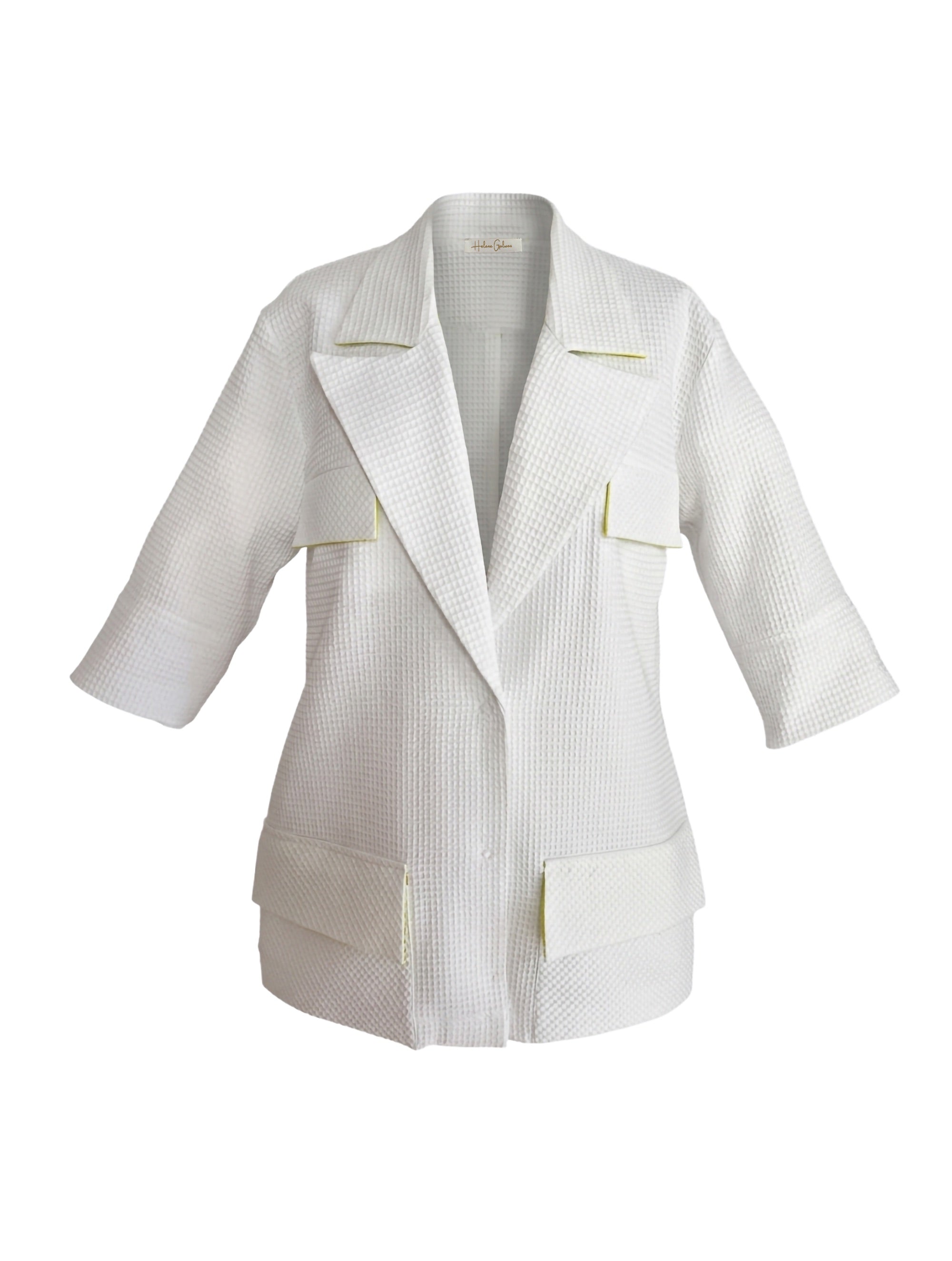 Leichter, figurbetonter Sommerblazer aus weißem Baumwoll-Waffelpiqué mit frischen limefarbenen Details. Ungefüttert, nahezu knitterfrei und Teil unserer Reborn Linie.