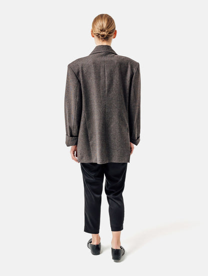 Oversize-Blazer mit breitem Revers, großen Schulterpolstern und überschnittenen Ärmeln sowie zwei Seitenschlitzen auf der Rückseite. Dieses Modell ist Teil unserer REBORN-Linie und steht für unsere "Zero-Waste-Politik", da mit Stoff aus Altbestand gefertigt.