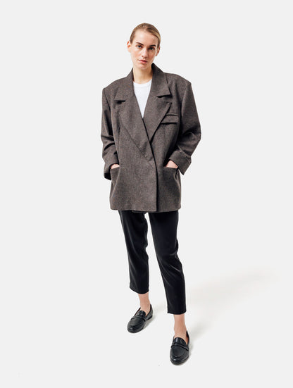 Oversize-Blazer mit breitem Revers, großen Schulterpolstern und überschnittenen Ärmeln sowie zwei Seitenschlitzen auf der Rückseite. Dieses Modell ist Teil unserer REBORN-Linie und steht für unsere "Zero-Waste-Politik", da mit Stoff aus Altbestand gefertigt.