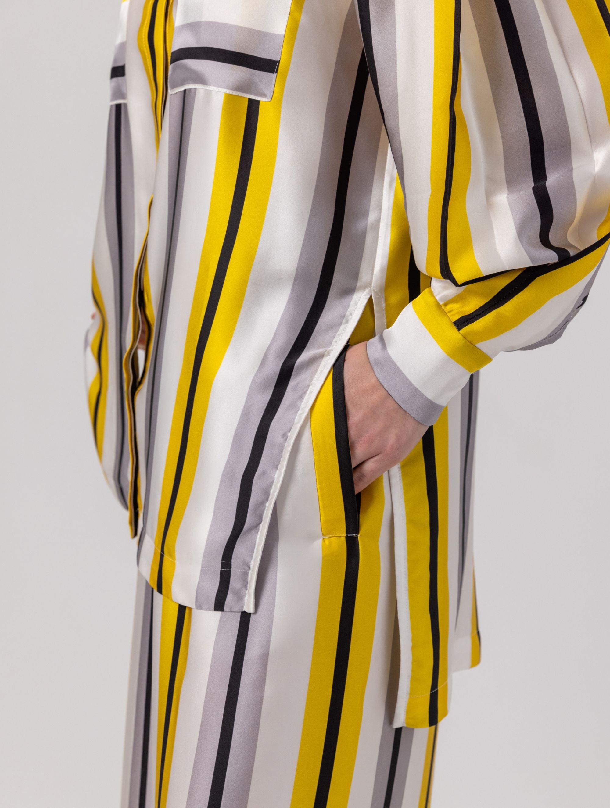 Bedruckte Oversize-Seidenbluse aus Satin mit Hemdkragen, aufgesetzten Taschen auf der Vorderseite und Kellerfalte auf der Rückseite sowie schwarzem Chiffonschal.  Hergestellt aus Naturfasern, sowie Stoffen aus unserem Altbestand im Sinne unserer "Zero-Waste-Politik".