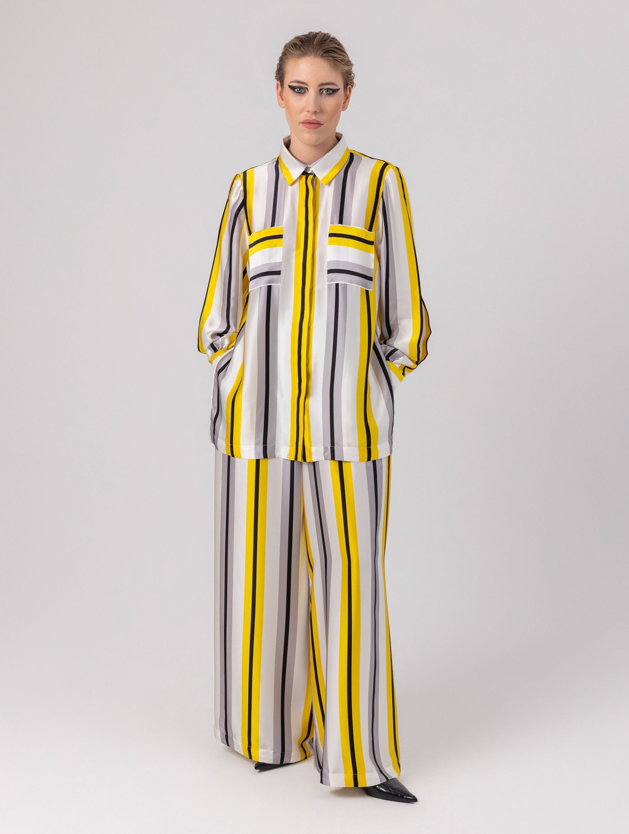 Bedruckte Oversize-Seidenbluse aus Satin mit Hemdkragen, aufgesetzten Taschen auf der Vorderseite und Kellerfalte auf der Rückseite sowie schwarzem Chiffonschal.  Hergestellt aus Naturfasern, sowie Stoffen aus unserem Altbestand im Sinne unserer "Zero-Waste-Politik".