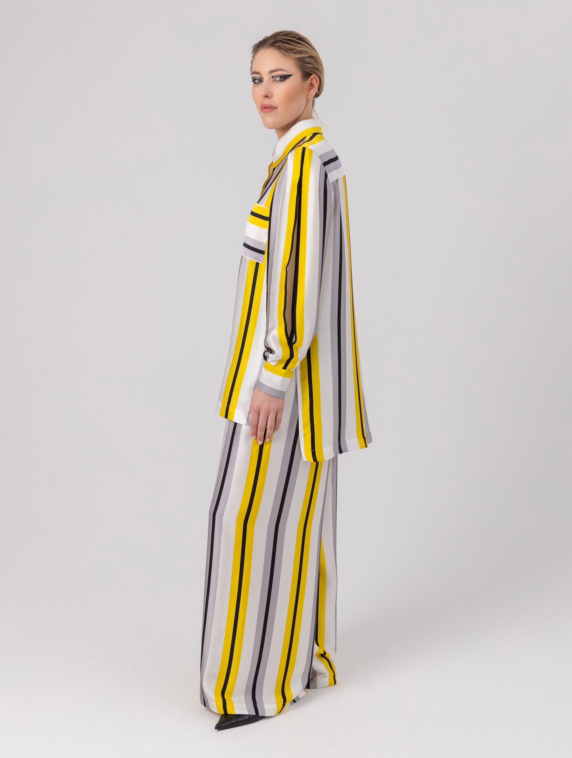 Bedruckte Oversize-Seidenbluse aus Satin mit Hemdkragen, aufgesetzten Taschen auf der Vorderseite und Kellerfalte auf der Rückseite sowie schwarzem Chiffonschal.  Hergestellt aus Naturfasern, sowie Stoffen aus unserem Altbestand im Sinne unserer "Zero-Waste-Politik".