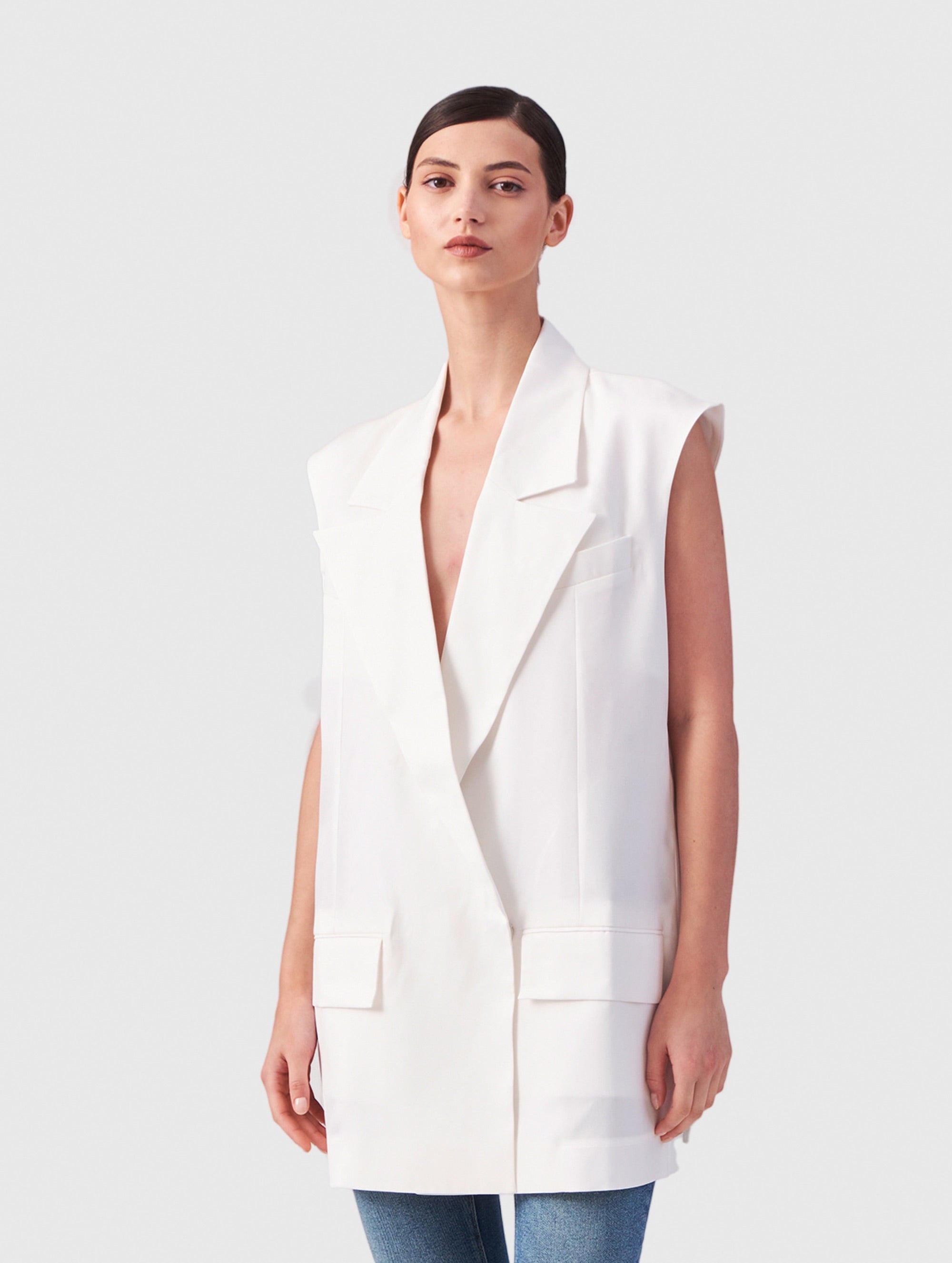 Weiße Oversized-Weste aus festem Tencel mit einem extrabreiten Revers und großen Taschenklappen, die für einen Hauch von Lässigkeit sorgen.