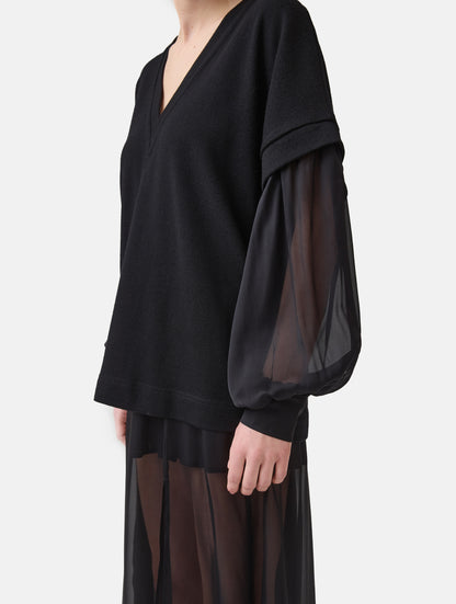 Locker geschnittener V-Auschnitt Pullover mit angesetzten weiten Bischofsärmeln aus feinem Seidenchiffon mit Hemdmanschetten und Knöpfen. Dieses Modell ist Teil unserer REBORN-Linie und steht für unsere "Zero-Waste-Politik", da mit Stoff aus Altbestand gefertigt.