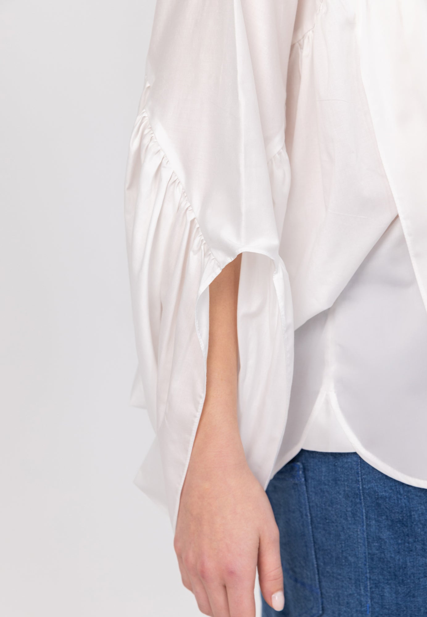 Bluse aus 100% feiner Baumwolle, Rundhalsausschnitt und breiten horizontal verlaufenden Volants im Vorder- und Rückteil sowie an den Ärmeln ausgestattet