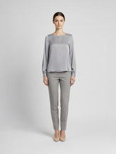 Langarm Seidenbluse mit Rundhalsausschnitt und Knopf im Nackenbereich.