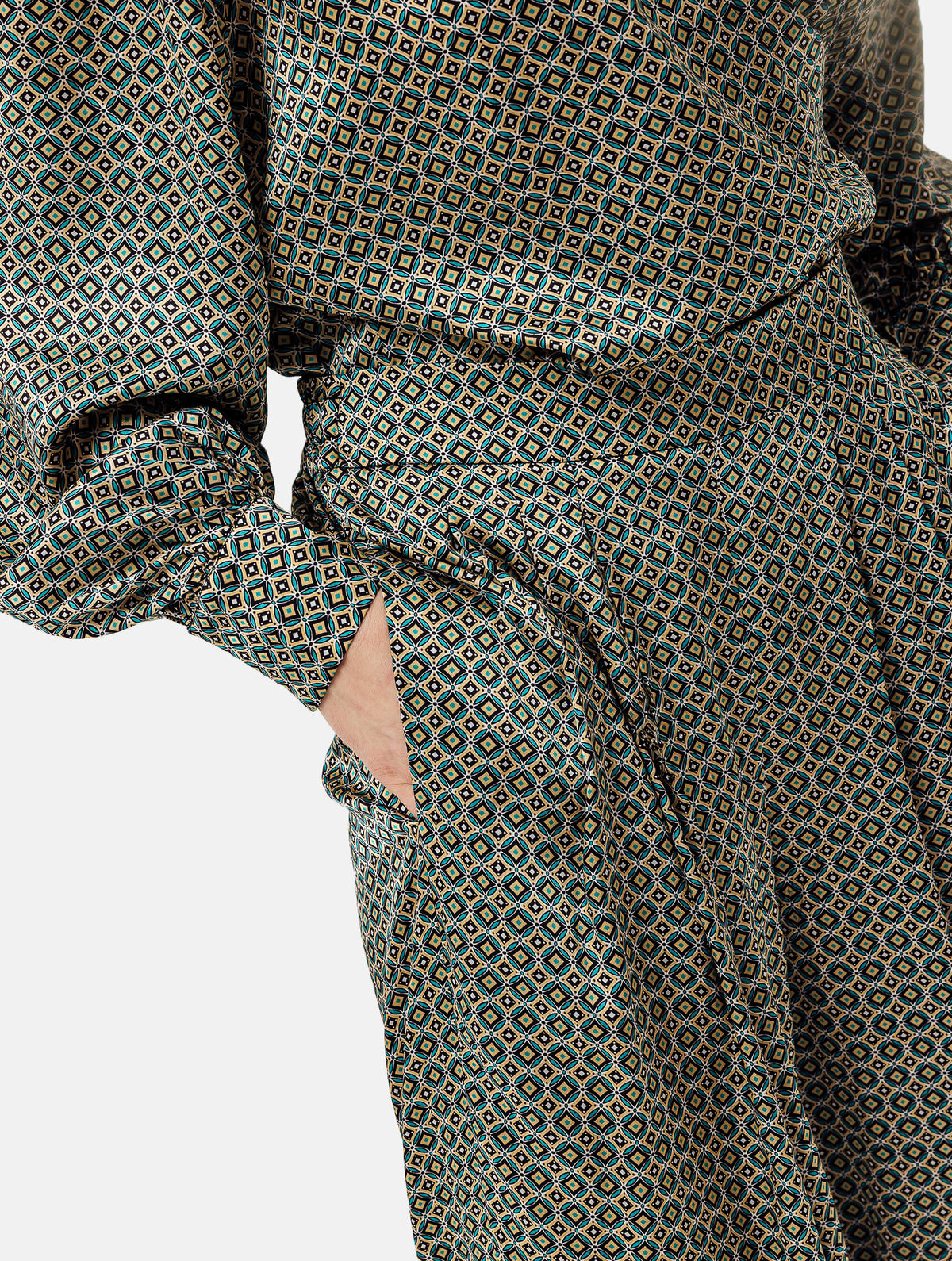 Weit geschnittene Hose mit elastischen Hosenbund, mit mehreren Abnähern am Bund, seitlichen Eingriffstaschen, aus hochwertigster bedruckter Seide gefertigt. Dieses Modell ist Teil unserer REBORN-Linie und steht für unsere "Zero-Waste-Politik", da mit Stoff aus Altbestand gefertigt.