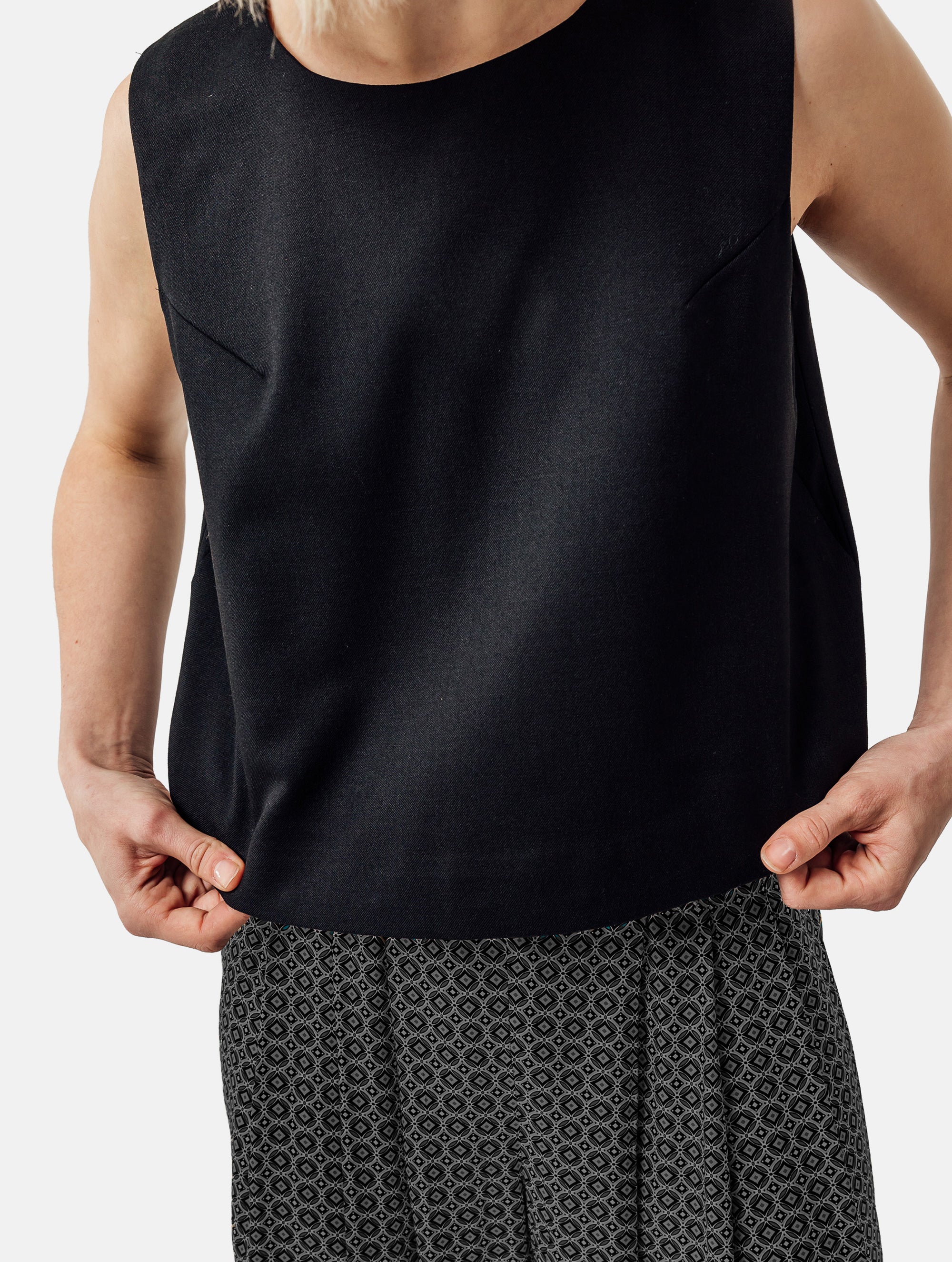 Grade geschnittenes kurzes Top aus Woll-Mix mit abnehmbaren langen Fransen aus Viskose. Dieses Modell ist Teil unserer Reborn Linie, da aus dem ehemaligen Top Alissa hergestellt worden ist.