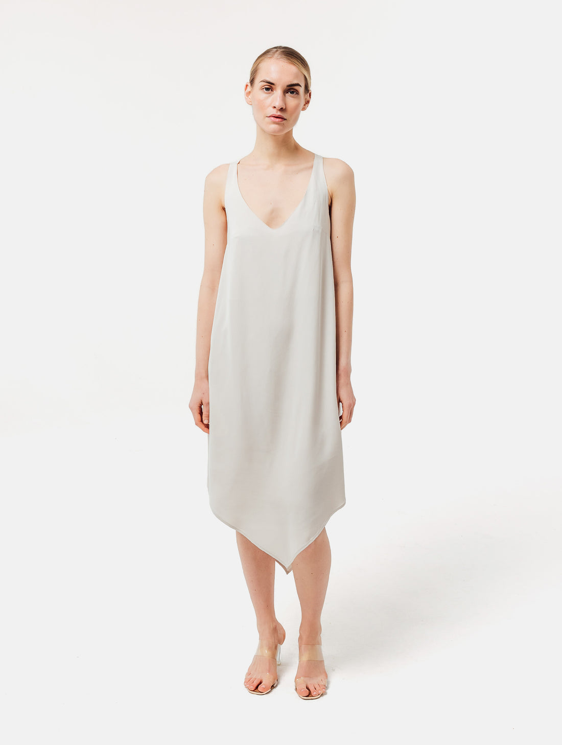 Zeitloses Trägerkleid aus fließender Satinseide mit tiefem V-Ausschnitt und spitz zulaufend für eine raffinierte Silhouette.