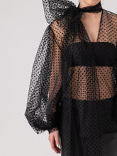 Extravagante gepunktete Tüllbluse mit tiefem V-Ausschnitt, weiten Dichterärmeln und extra langem Schalkragen. Dieses Modell ist Teil unserer REBORN-Kollektion und steht für unsere "Zero-Waste-Politik".