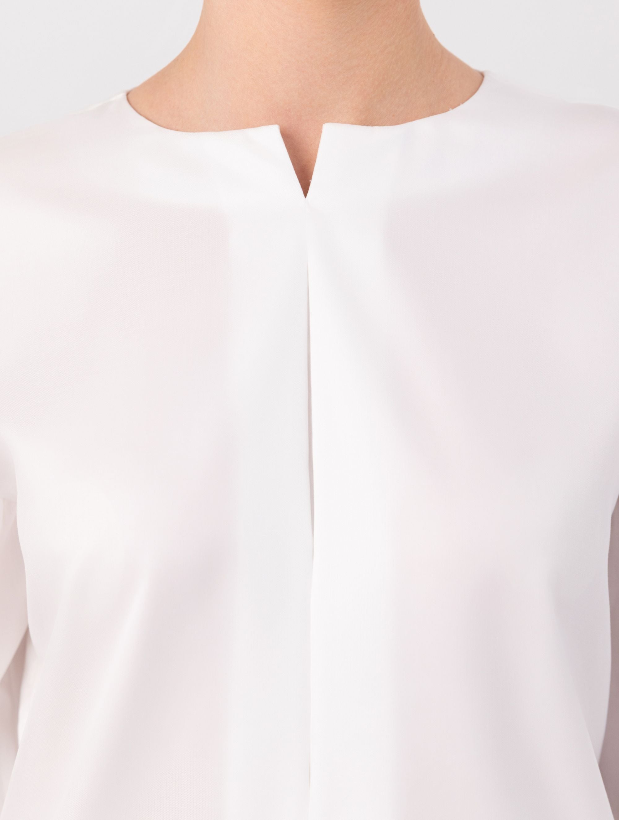 Eine locker sitzende Bluse mit Rundhalsausschnitt, überschnittenen Schultern, mittigen Kellerfalten auf Vorder- und Rückseite und kurzen Seitenschlitzen. Modernes Design für den Alltag. Dieses Produkt stammt aus unserer „Reborn“-Kollektion, in der wir Artikeln neues Leben einhauchen, indem wir sie modifizieren.