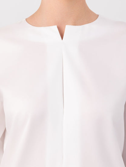 Eine locker sitzende Bluse mit Rundhalsausschnitt, überschnittenen Schultern, mittigen Kellerfalten auf Vorder- und Rückseite und kurzen Seitenschlitzen. Modernes Design für den Alltag. Dieses Produkt stammt aus unserer „Reborn“-Kollektion, in der wir Artikeln neues Leben einhauchen, indem wir sie modifizieren.