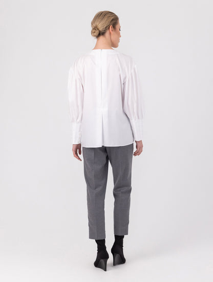 Eine locker sitzende Bluse mit Rundhalsausschnitt, überschnittenen Schultern, mittigen Kellerfalten auf Vorder- und Rückseite und kurzen Seitenschlitzen. Modernes Design für den Alltag. Dieses Produkt stammt aus unserer „Reborn“-Kollektion, in der wir Artikeln neues Leben einhauchen, indem wir sie modifizieren.