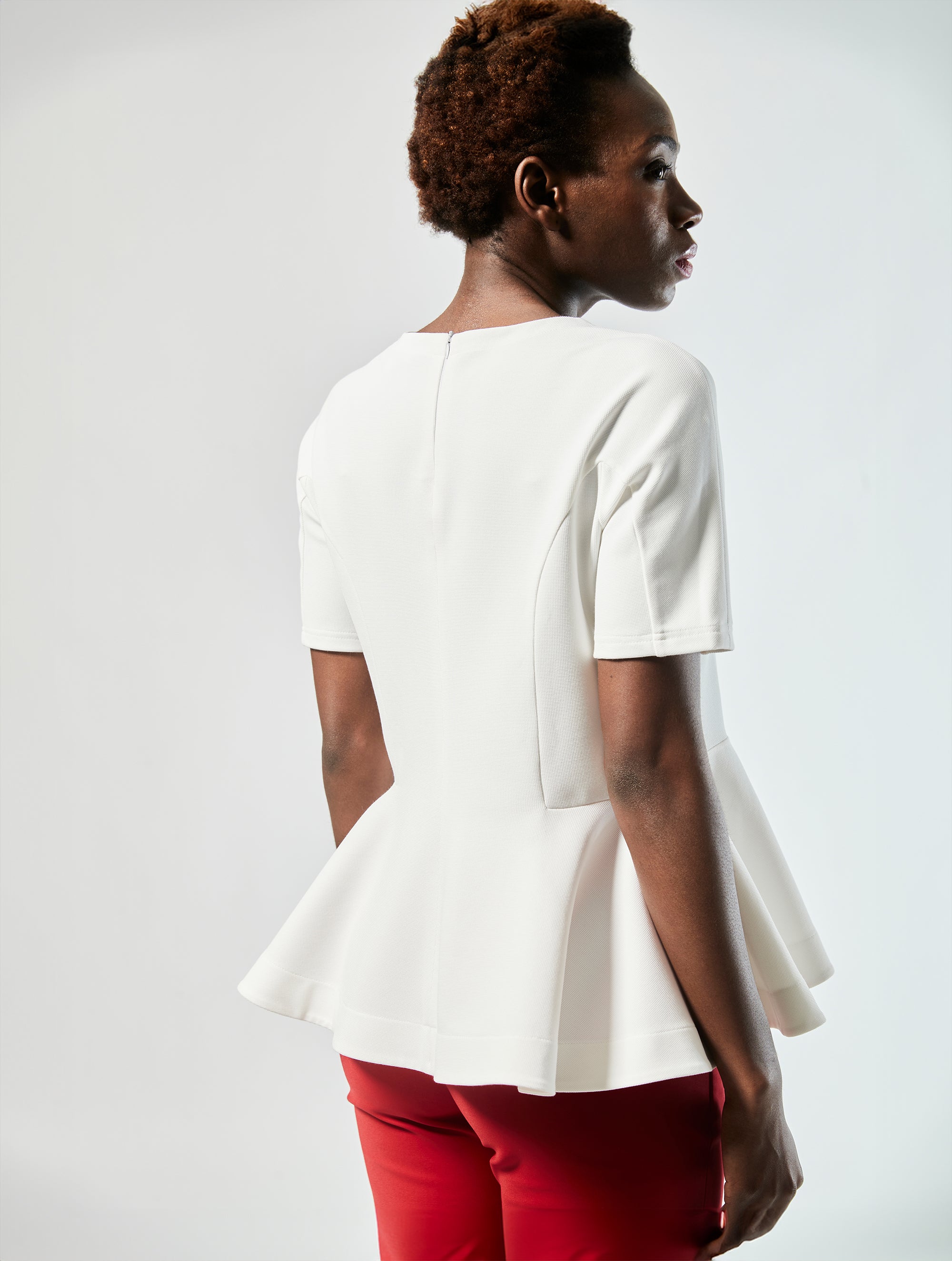 Bluse aus festem Baumwoll-Mix, tailliertem Schnitt mit peplum Schößchen und weit ausgestelltem Saum